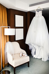 Fototapeta na wymiar Wedding dress in the room and shoes on a white chair