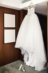 Wedding dress in the room and shoes on a gray floor