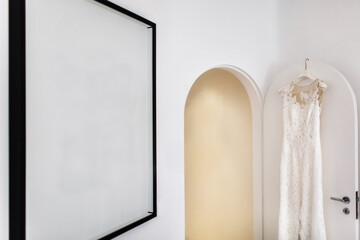 Wedding dress hanging on the door in the white room