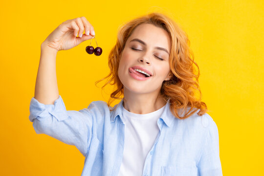 Charming Woman With Cherry Licking Lips, Isolated On Yellow.