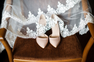 Wedding shoes and veil on the brown chair