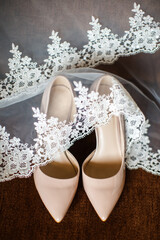 Wedding shoes and veil on the brown background