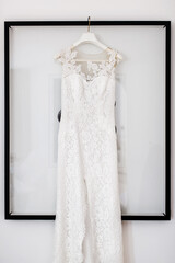 Wedding dress hanging on the picture in the white room