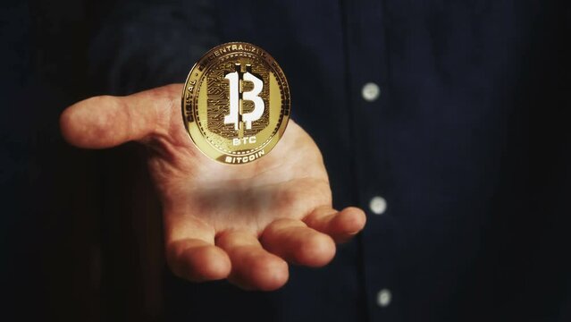 Bitcoin BTC cryptocurrency rotating 3d coin hovers over the hand. Businessman with symbol floating above the hand. Business and technology seamless and looped abstract concept.