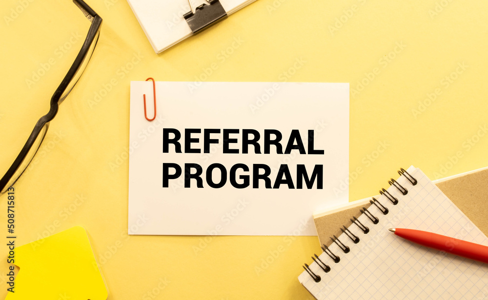 Aufkleber referral program open notepad on desktop near white keyboard and yellow stickers and glasses