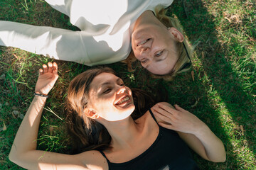 Top view of mature mother and daughter lay on the grass on sunny summer day