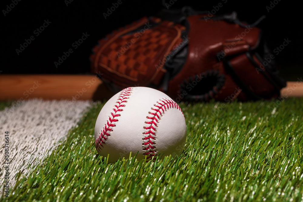 Poster baseball on grass field low angle close up with mitt and bat soft focus behind