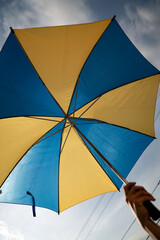 Arm Holding Umbrella with Blue and Yellow Pattern - 508716855