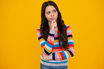 Thoughtful teenager girl touch chin and thinking, pensive child making idea, posing isolated on yellow isolated background. Thinking teenager girl, thoughtful emotion.