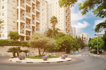 Fototapeta premium Israeli cityscape with circular motion and decorational flowerbed with flowers in wooden tubs