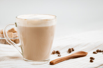 Latte coffee with foam on a light kitchen table, copy space