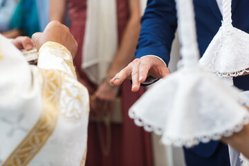 The priest in the church puts rings on the bride and groom