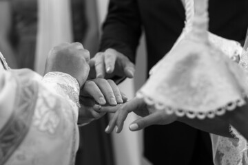 The priest in the church puts rings on the bride and groom