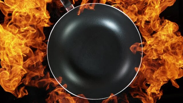 Super slow motion of empty wok pan and fire blast on black background. Filmed on very high speed cinema camera, 1000 fps.