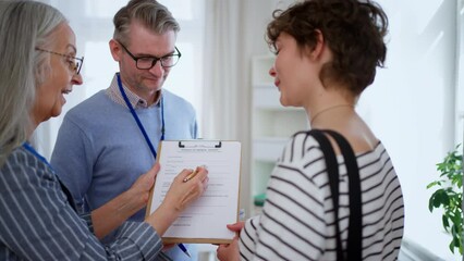 Job centre employee helping young woman to fill form to find a job.
