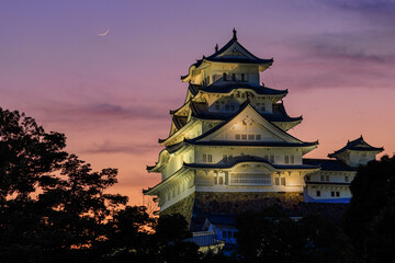 Obraz premium Crescent moon and sunset colors over Himeji Castle