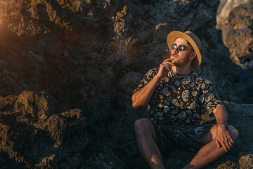 young man with sunglasses smoking a joint