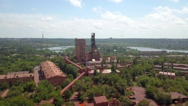 Mine railway and quarry red iron ore headframe aerial drone forward push in camera movement Krivoy Rog Ukraine.