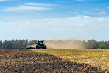 Obraz premium The tractor plows the land. Agriculture image.