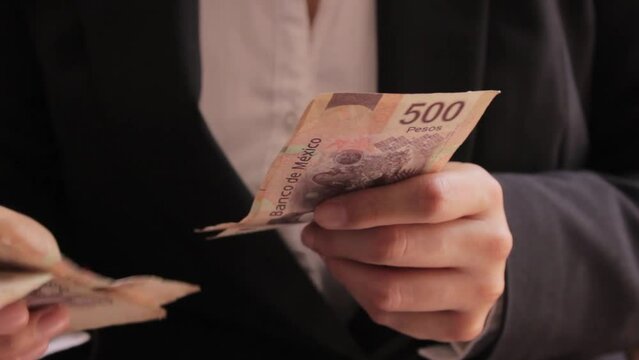 Manos de mujer de negocios contando billetes de quinientos pesos