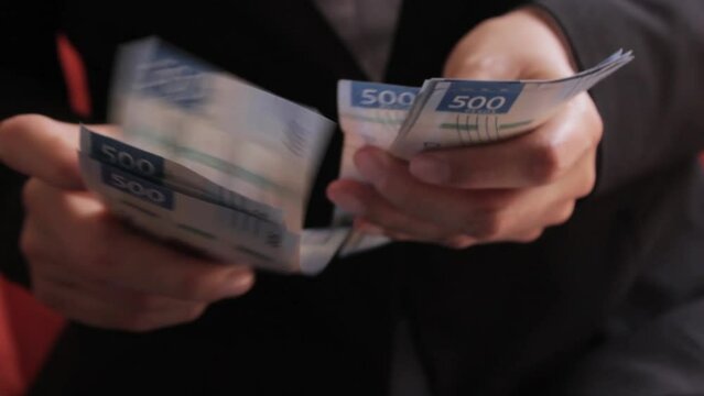 Manos de personas contando billetes de quinientos pesos mexicanos
