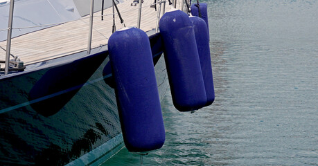 Blue fenders on a hull of a sailboat