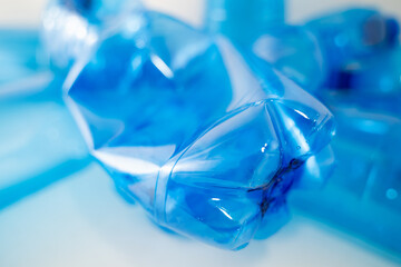 Blue plastic PET bottle in close up on white background. Focus on details