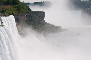 The majestic Niagara Falls with the small Maid of the Mist deep down.