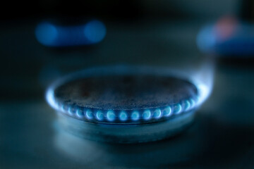 
The gas stove burner glows with a blue flame
