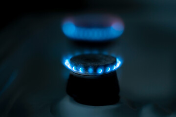 
The gas stove burner glows with a blue flame
