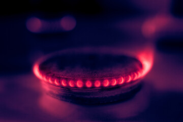 
The gas stove burner glows with a red flame
