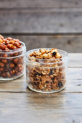 Rosted chickpeas and gronola in jars on a wooden picnic table