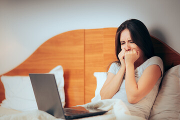 Unhappy Woman Crying in front at her Laptop at Home