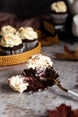 A chocolate cupcake is broken with a fork, berry filling is visible.