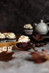 Chocolate cupcakes in a wicker basket. One cupcake cut with a fork