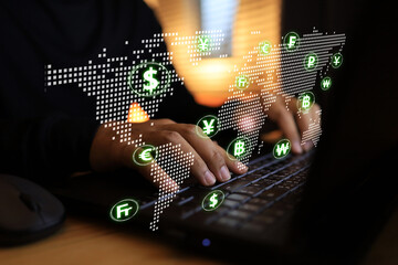 Businessman hand working with a laptop computer screen in a digital world map and foreign currency...