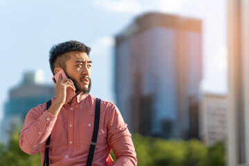 Asian businessman talking to the mobile outdoors