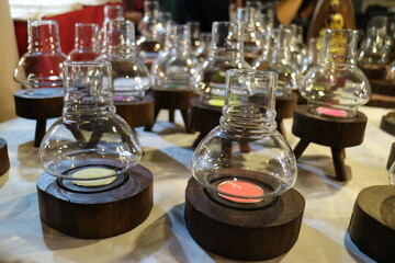 There are many candlesticks made of clear glass on the table