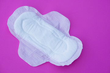 White sanitary pad 
on pink background. Concept: female's hygienic product for period's day. Protect from menstruation blood to stain underwear clothes. Woman healthcare. Intimate hygiene. Top view.