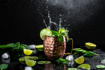 Cocktail with ice, in a copper mug on a black background. splashing Moscow mule alcoholic cocktail © Надія Коваль