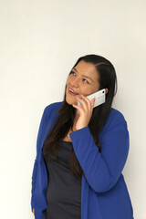 Adult latin woman over isolated white background with cell phone in victory position shows happy and excited