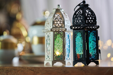 Ornamental Arabic lantern with burning candle glowing  and  beautiful tea set  as background