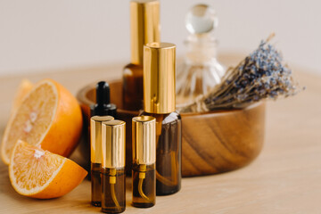 Essential oil in bottles with the aroma of orange and lavender lying on a wooden surface