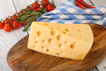 Maasdam cheese piece over board