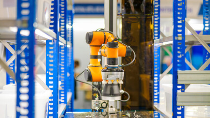  Smart warehouse concept: The COBOT (Collaborative Robot) with gripper is automatically picking...
