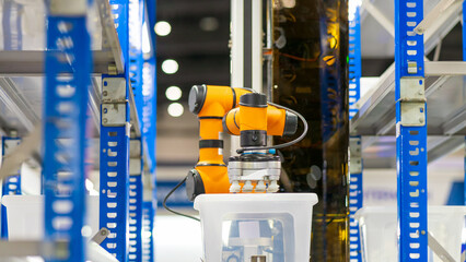  Smart warehouse concept: The COBOT (Collaborative Robot) with gripper is automatically picking...