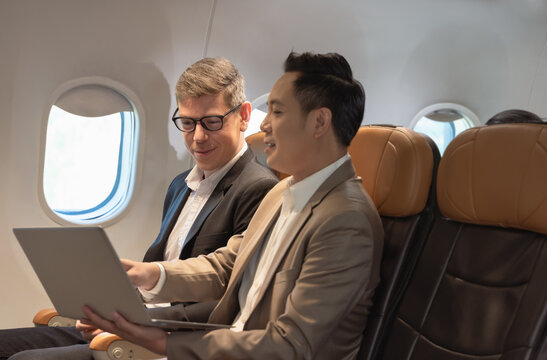 Two Business People Working Together On Laptop During Flight