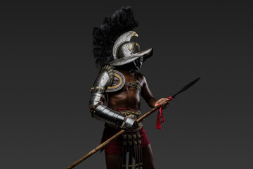 Photo of antique arena fighter of african descent dressed in plumed helmet and armor holding spear.