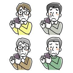 スマホを見て泣く男性