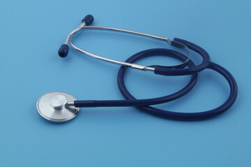 Stethoscope on blue background close-up. Symbol of medicine and medical exam.